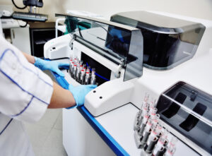 a female scientist near the analyzer in a medical microbiological laboratory. Equipment for analysis, DNA, PCR